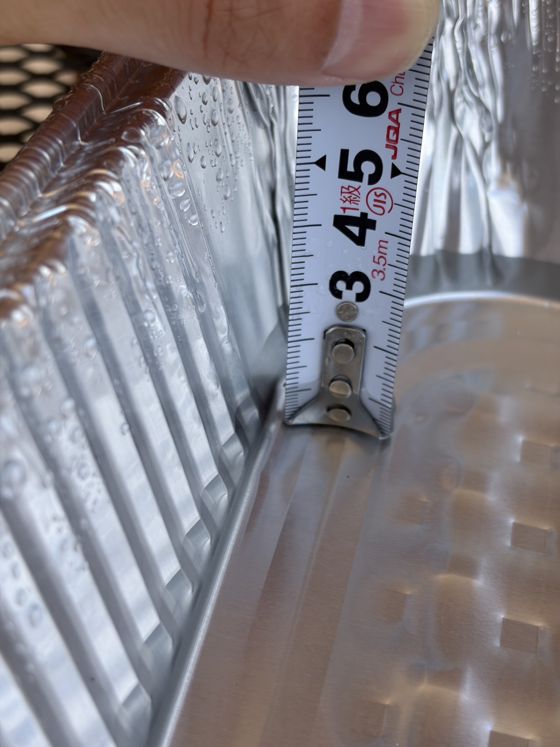 20分散水後のトレーの水深を測り約11mmだった様子
